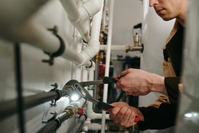 Technician inspecting commercial plumbing pipes in Monrovia
