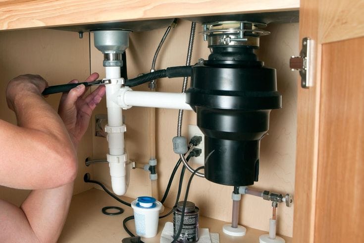Plumber repairing a garbage disposal in Monrovia