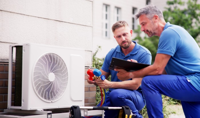 HVAC technicians installing an outdoor air conditioning unit in Monrovia