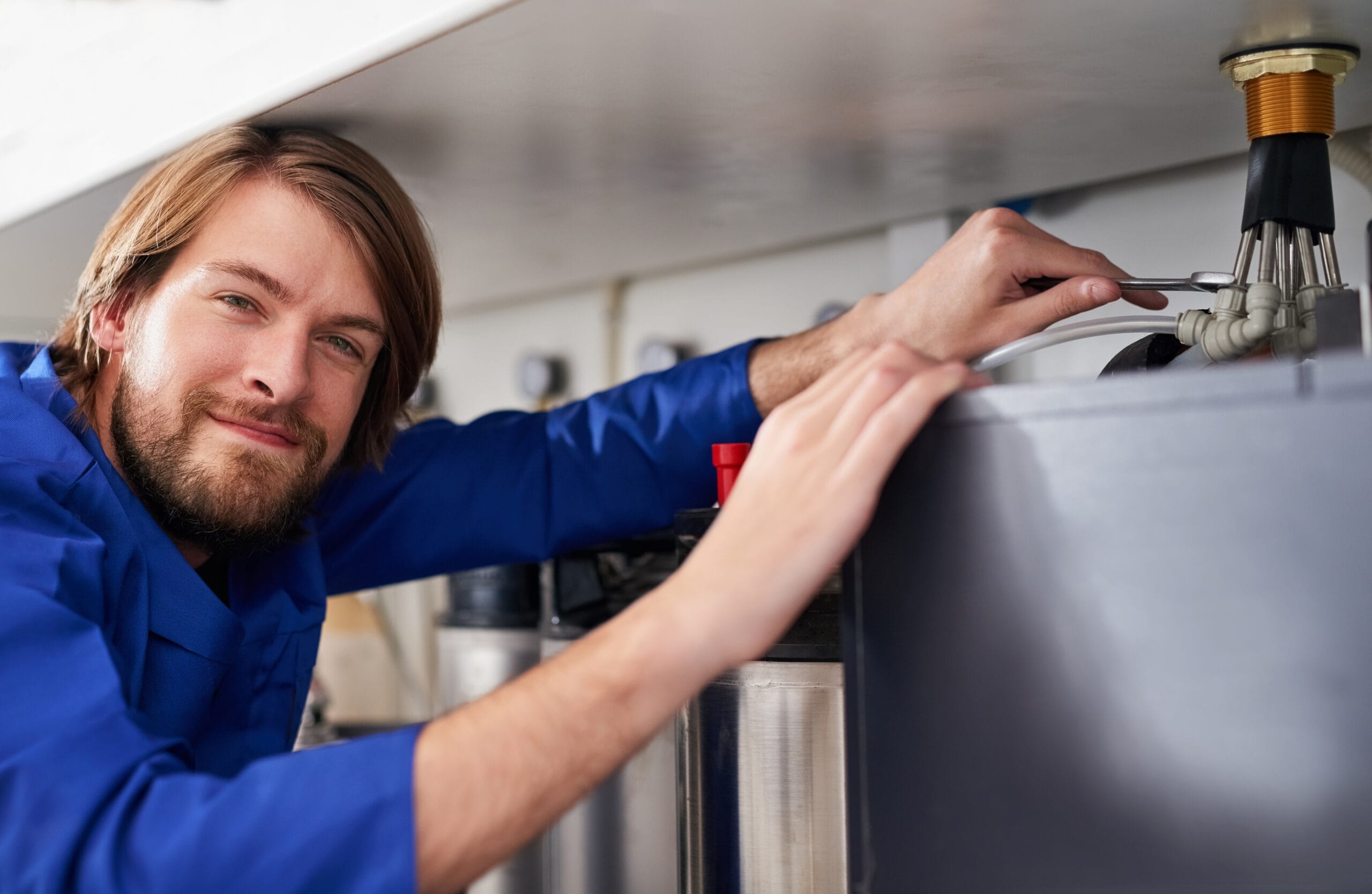 Technician servicing a residential water heater tank in Monrovia